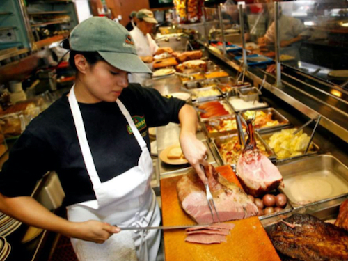 Picture of restaurant worker carving meat