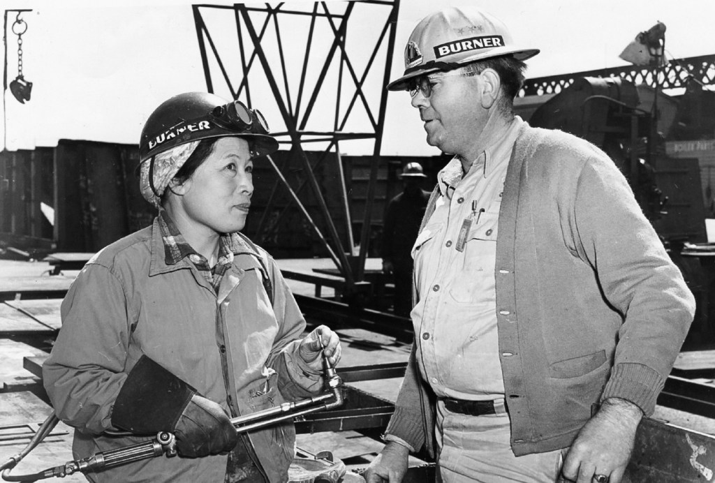 Picture of woman and a man wearing hard hats at a construction site